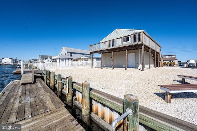 rear view of property with a water view and fence