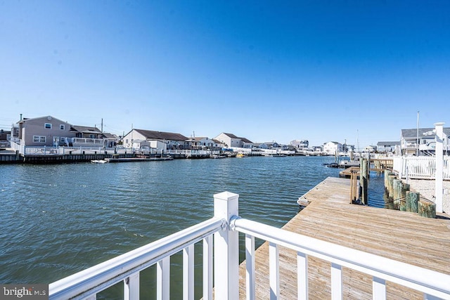 view of dock featuring a water view and a residential view