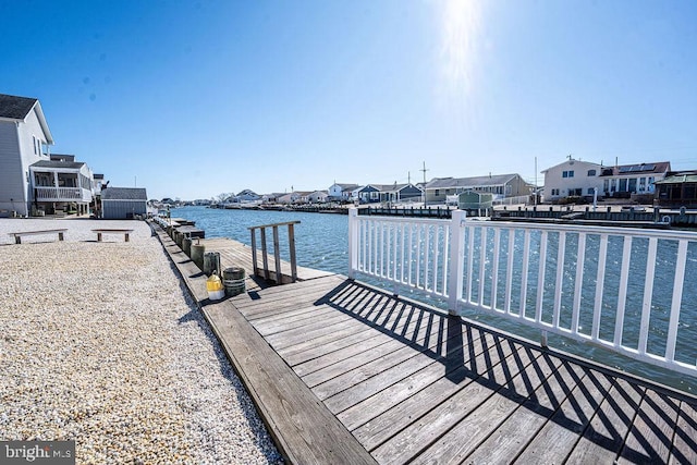 view of dock with a residential view and a water view