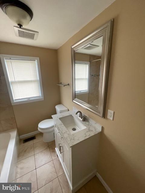 bathroom featuring toilet, baseboards, visible vents, and vanity