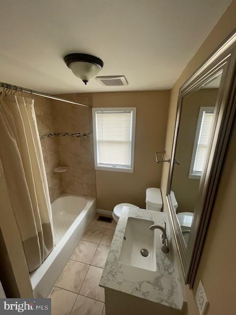 full bath featuring visible vents, shower / bathtub combination with curtain, toilet, vanity, and tile patterned floors