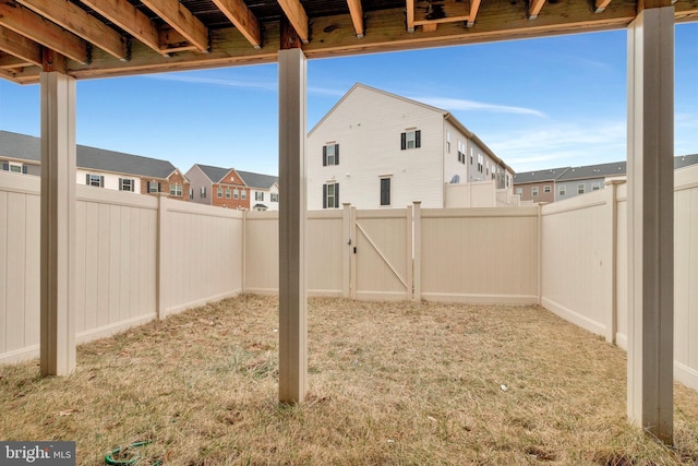 view of yard featuring a residential view, a gate, and a fenced backyard