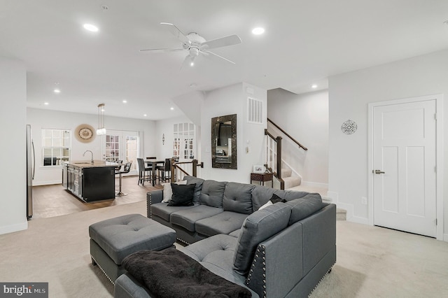living room featuring light carpet, stairway, visible vents, and recessed lighting