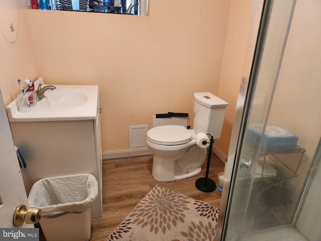 full bathroom with toilet, wood finished floors, vanity, baseboards, and a shower stall