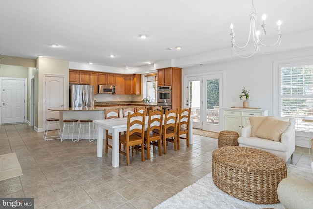 dining room featuring light tile patterned floors, baseboards, a notable chandelier, and recessed lighting