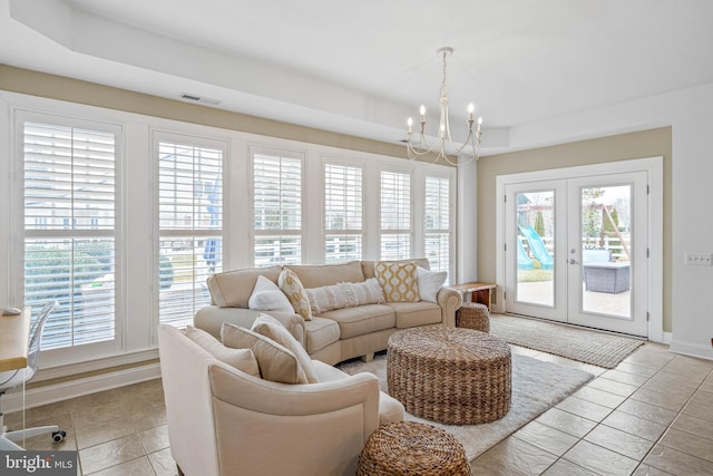 living room featuring a chandelier, visible vents, baseboards, french doors, and a raised ceiling