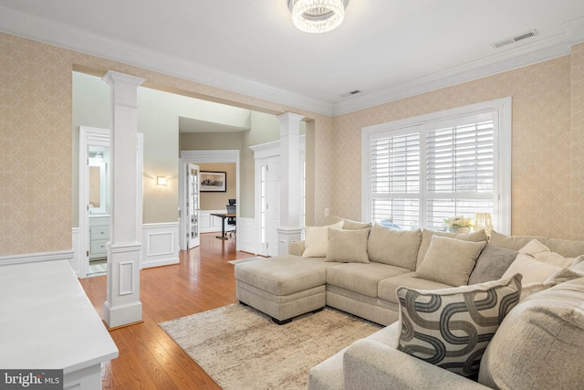 living room featuring visible vents, decorative columns, and wallpapered walls