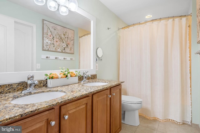 full bath with double vanity, a sink, toilet, and tile patterned floors