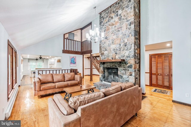 living room featuring a fireplace, a baseboard heating unit, wood finished floors, high vaulted ceiling, and baseboards