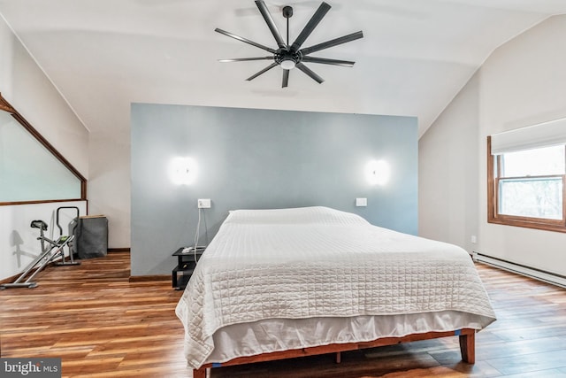 bedroom with lofted ceiling, a baseboard heating unit, and wood finished floors