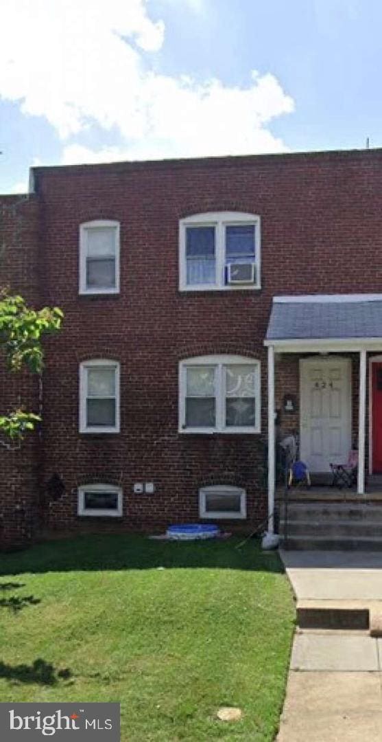 multi unit property featuring a front yard and brick siding