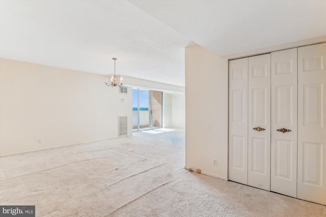 interior space with carpet floors, visible vents, and a chandelier