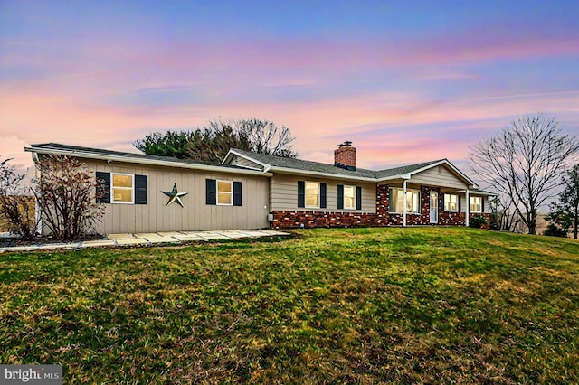 single story home with a front lawn, a chimney, and brick siding