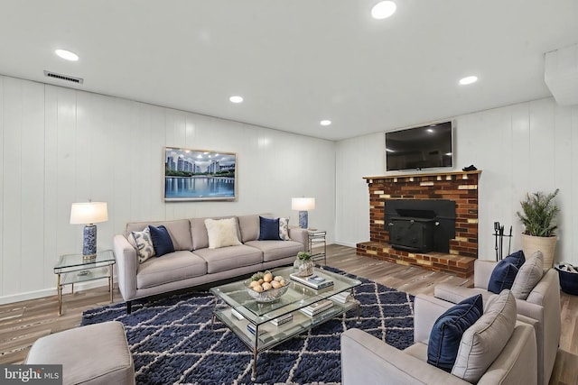 living room with baseboards, wood finished floors, visible vents, and recessed lighting