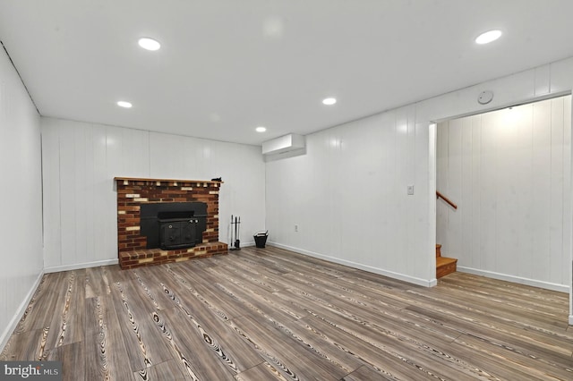 unfurnished living room with stairs, baseboards, wood finished floors, and recessed lighting