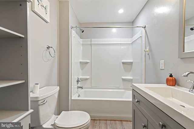 full bath with vanity, shower / washtub combination, wood finished floors, and toilet