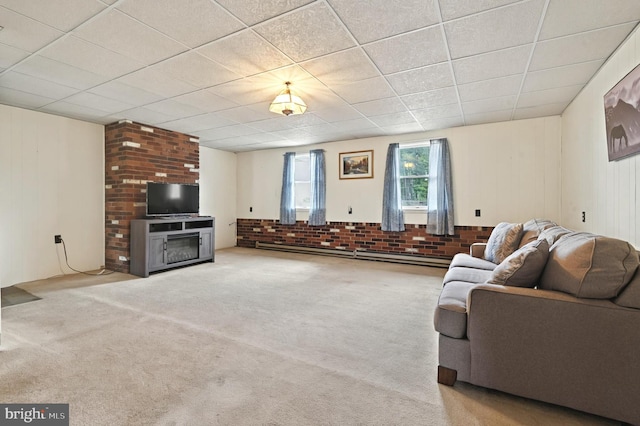 living area featuring carpet floors, a baseboard radiator, a fireplace, and brick wall