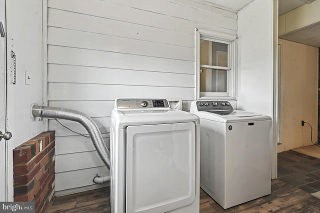 laundry area featuring dark wood-type flooring, laundry area, and washer and clothes dryer