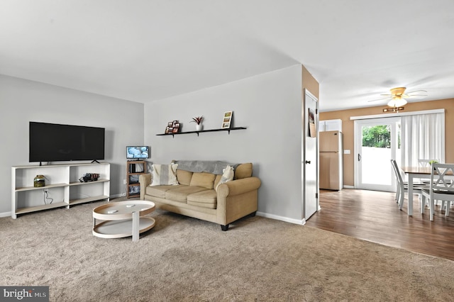 carpeted living room featuring ceiling fan and baseboards