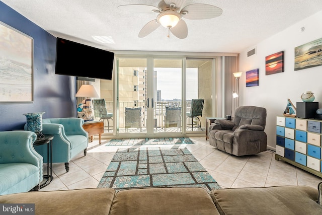 living area with a wall of windows, tile patterned flooring, visible vents, and a textured ceiling