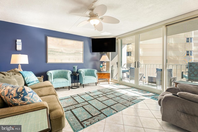 tiled living room with ceiling fan, a textured ceiling, and floor to ceiling windows