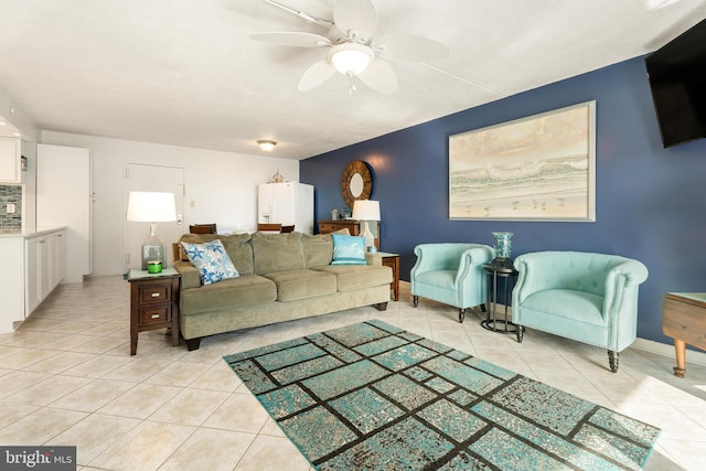 living room featuring light tile patterned flooring, ceiling fan, and baseboards