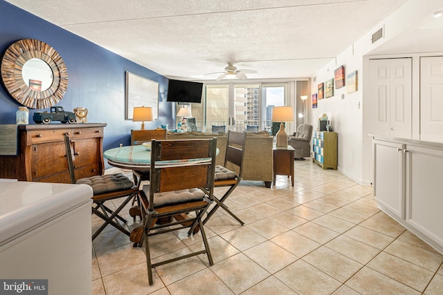 dining room featuring light tile patterned floors, ceiling fan, visible vents, and a textured ceiling