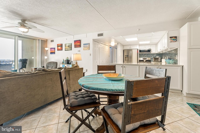 dining room with a ceiling fan, visible vents, and light tile patterned floors