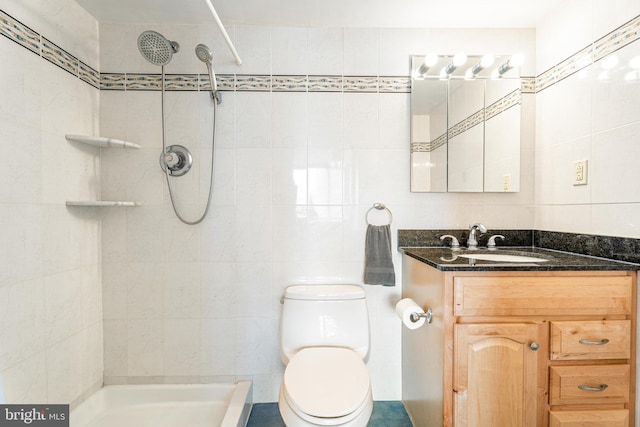 full bathroom featuring toilet, a tile shower, and tile walls