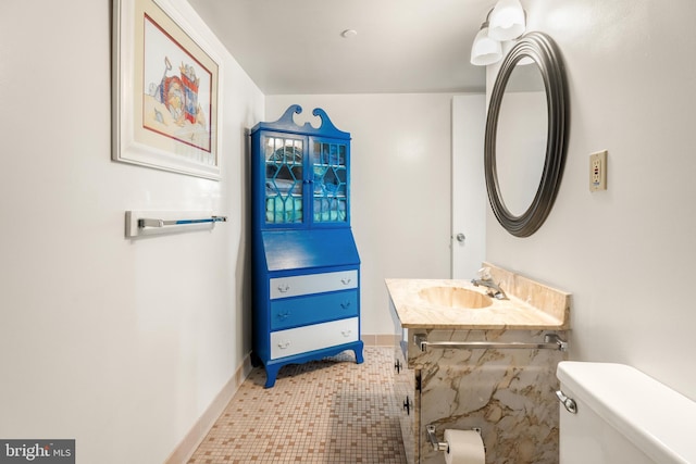 bathroom with toilet, baseboards, and a sink