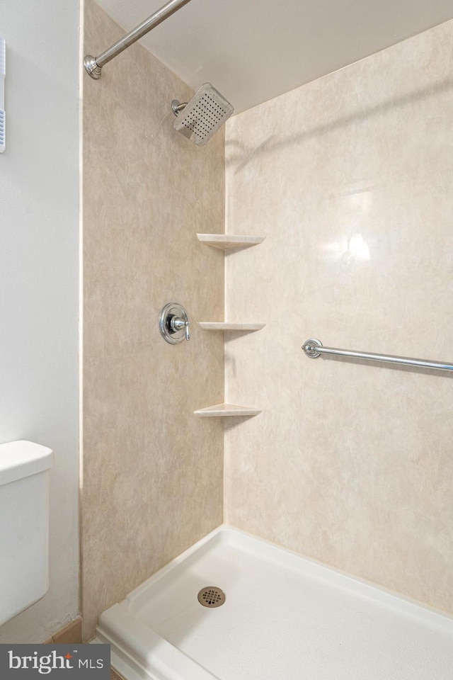 bathroom with walk in shower and toilet