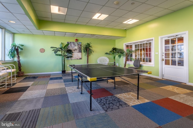 game room featuring carpet floors, a paneled ceiling, and baseboards