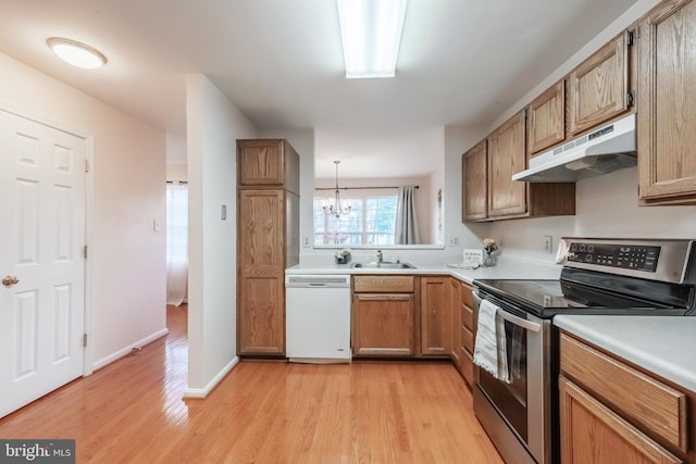 kitchen featuring under cabinet range hood, light countertops, white dishwasher, and electric range