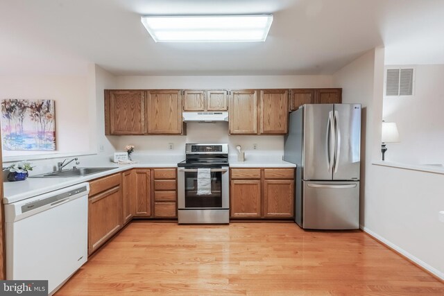 kitchen featuring light countertops, visible vents, appliances with stainless steel finishes, a sink, and under cabinet range hood