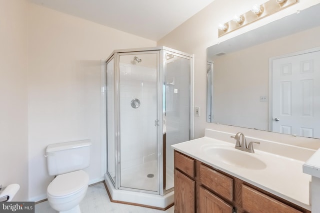 full bath featuring toilet, a stall shower, and vanity