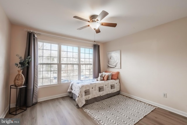 bedroom featuring ceiling fan, wood finished floors, and baseboards