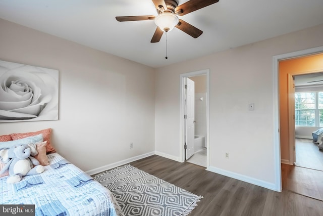 bedroom featuring ceiling fan, ensuite bath, baseboards, and wood finished floors