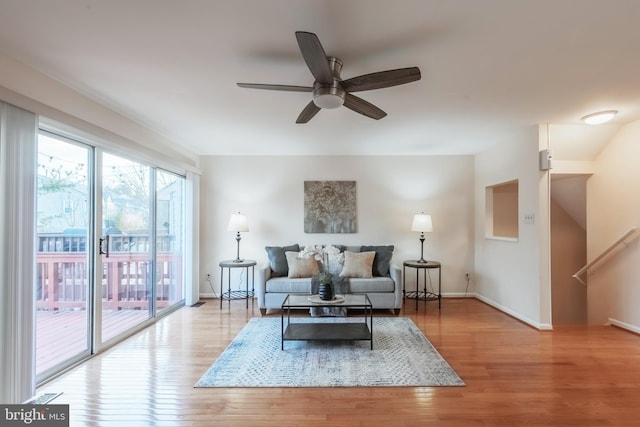 living area with ceiling fan, baseboards, and wood finished floors