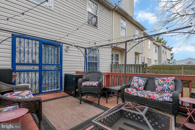 wooden terrace featuring outdoor lounge area and fence