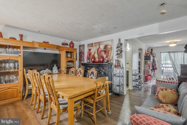 dining room with a textured ceiling and wood finished floors