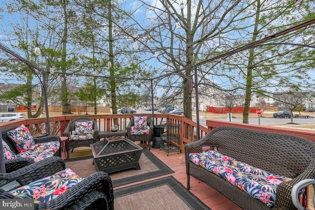 wooden deck featuring an outdoor living space with a fire pit