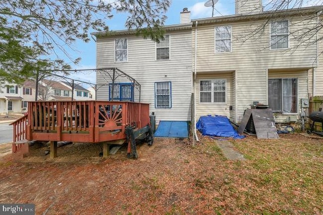 back of property featuring a deck and a chimney