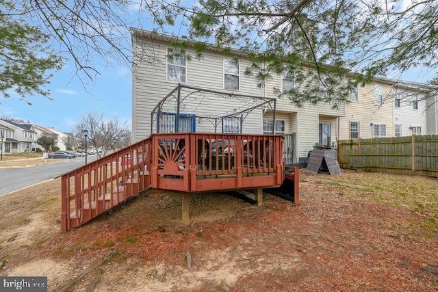 rear view of property with fence and a deck