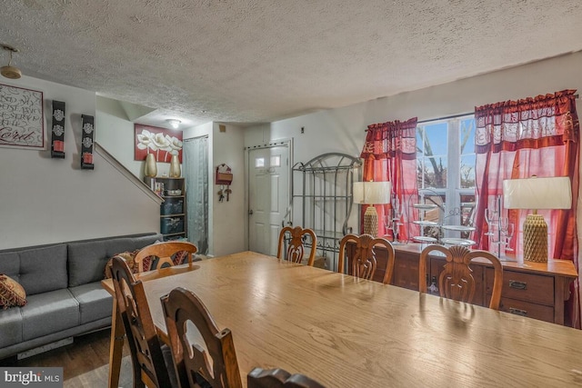 dining area with a textured ceiling and wood finished floors