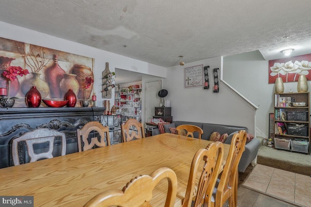 dining area featuring a textured ceiling and tile patterned floors