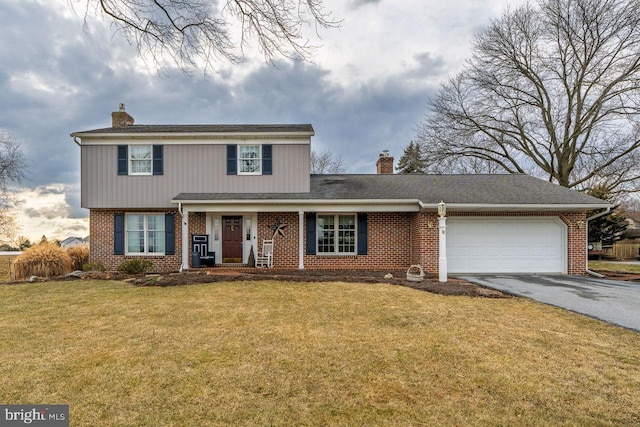 traditional-style house with brick siding, a chimney, a front yard, a garage, and driveway