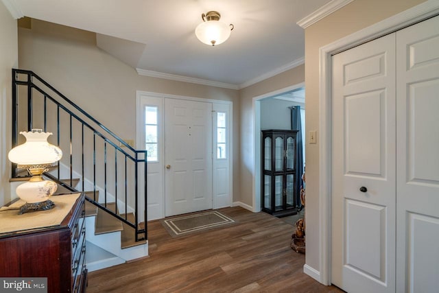 entrance foyer featuring ornamental molding, dark wood finished floors, stairway, and baseboards