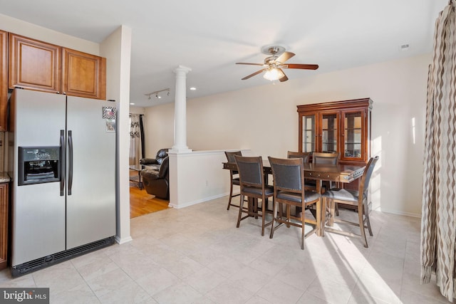 dining room featuring ornate columns, light tile patterned floors, baseboards, and a ceiling fan