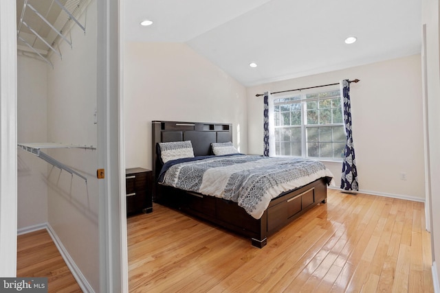 bedroom with lofted ceiling, light wood-style floors, baseboards, and recessed lighting