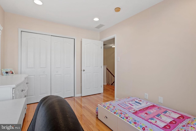 bedroom featuring light wood-type flooring, visible vents, a closet, and recessed lighting